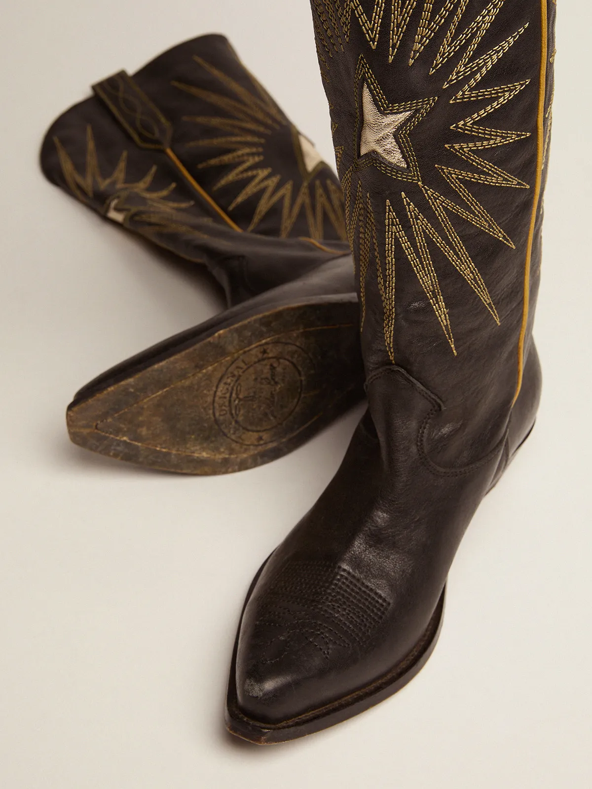 Women's boots in black leather with platinum star inlay